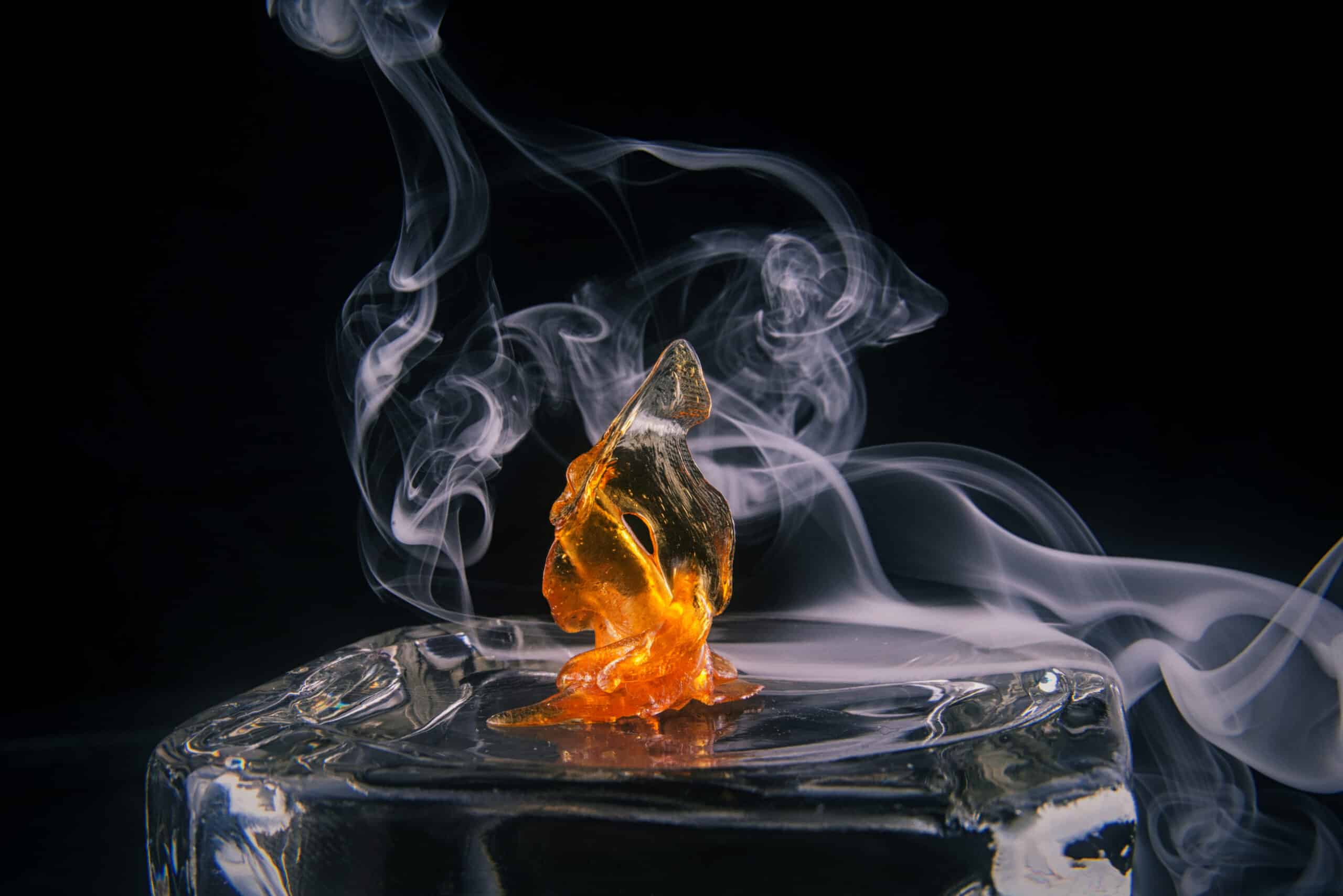 Melted cannabis oil concentrate aka shatter with smoke isolated over dark background
